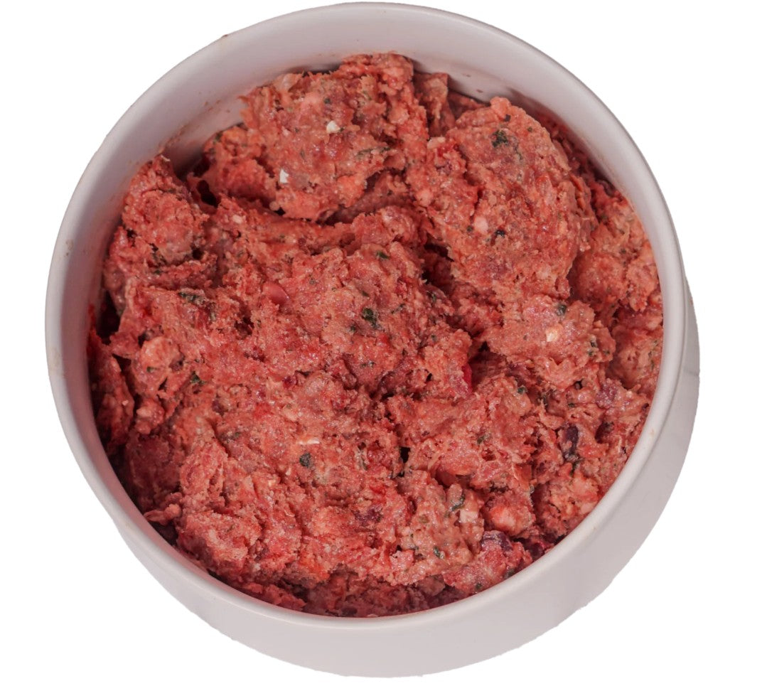 Raw ground meat in a white bowl on a white background
